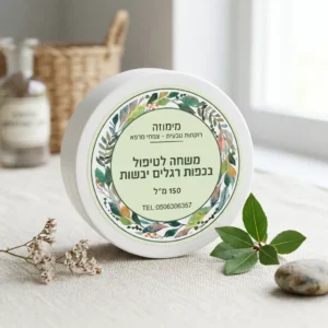 משחה טבעית לטיפול בכפות הרגלים בקופסא לבנה פלסטיק, סגורה עם מכסה עם תווית המוצר ועלי צמחים ברקע.